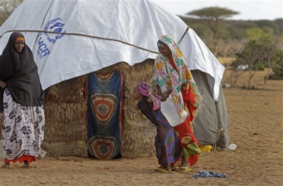 A displaced woman, right, lifts water off her child's back after she returned from a well some distance from their home in the town of Dadaab, Kenya, on July 30. More than 11 million people are estimated to need help as a result of East Africa's worst drought in 60 years in Kenya, Ethiopia, Somalia, Eritrea and South Sudan.
